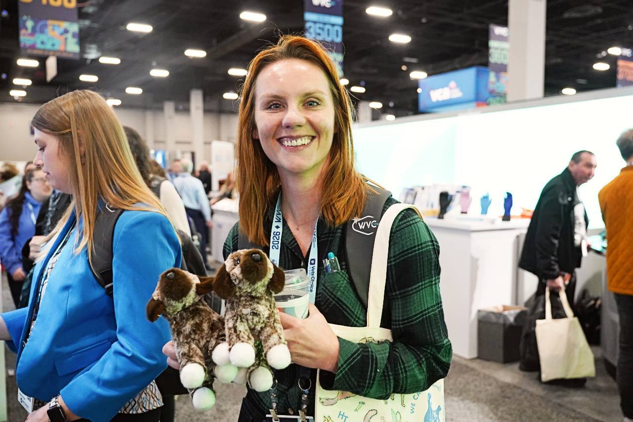 participant at wvc vegas holding two stuffed animal dogs